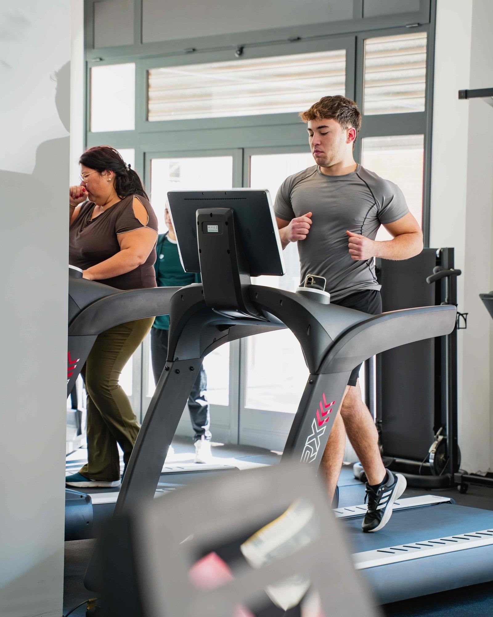 Dimagrimento a Pachino - uomo e donna che corrono su treadmill in palestra moderna