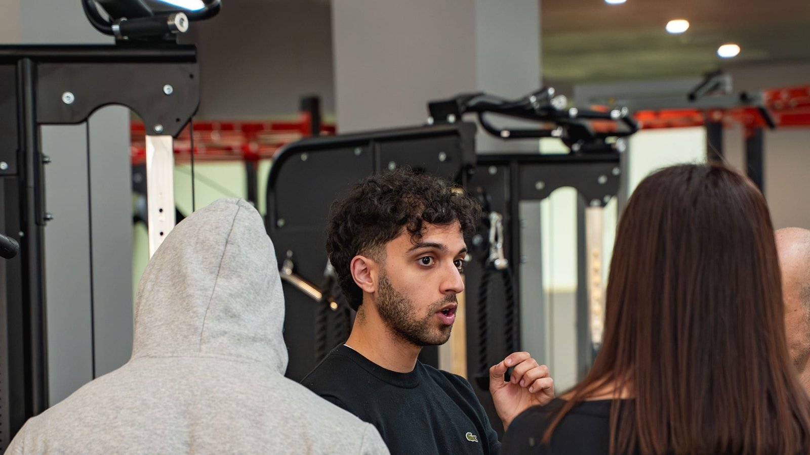 Personal trainer di Lucen Wellness a Pachino che spiega un esercizio a due clienti